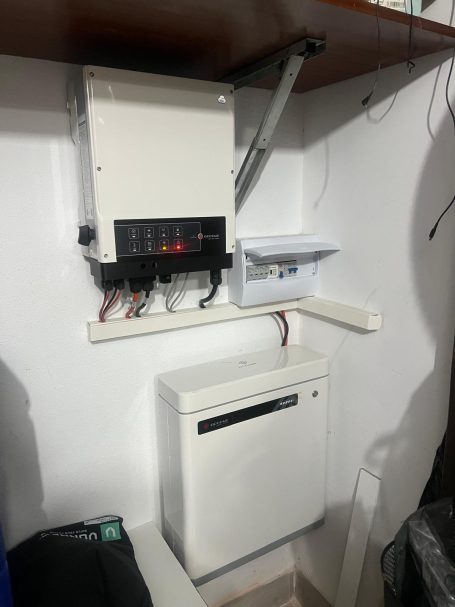 Controlador eléctrico montado en pared con un pequeño armario y un dispositivo debajo.