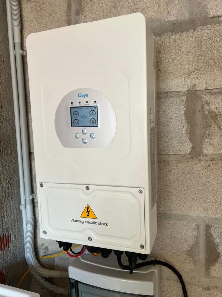 Controlador solar montado en la pared, con pantalla y conexiones eléctricas.