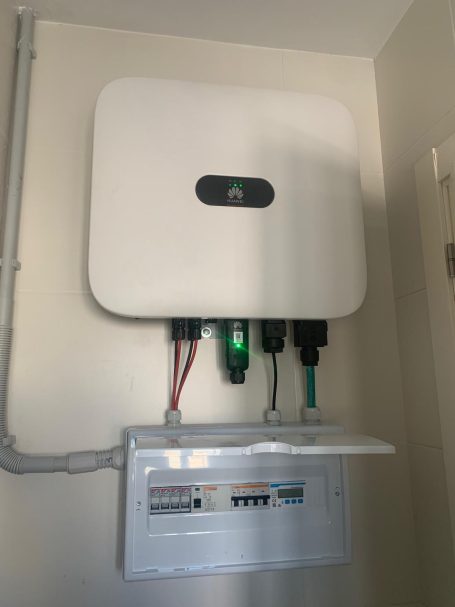 Dispositivo eléctrico montado en la pared con conexiones y un panel de control abajo.