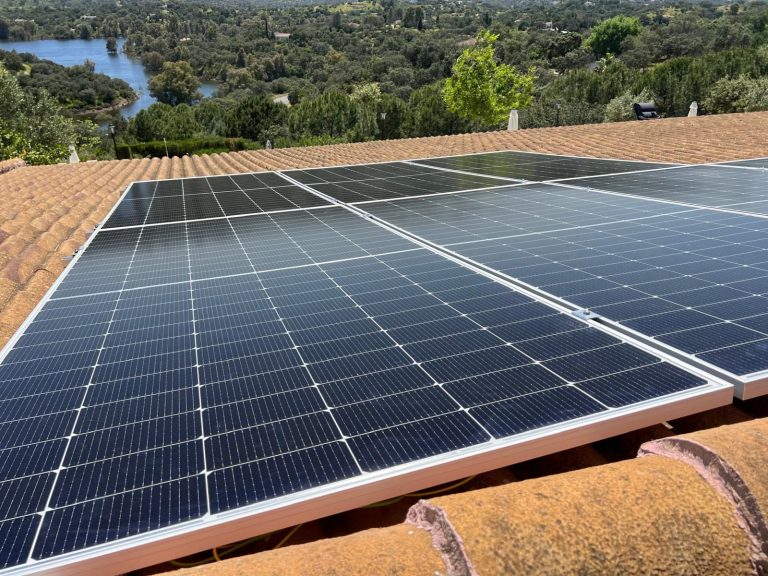 Paneles solares instalados con vistas a un lago.